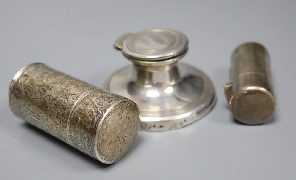A silver capstan inkwell and two silver-cased cylindrical scent bottles